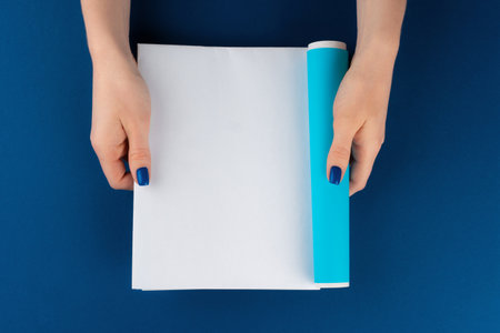 Female hands holding blank magazine with copy spaceの写真素材