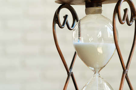 Sandglass on wooden bakground closeup. Time concept