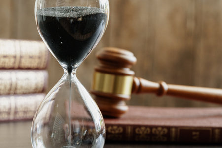 Court concept. Hourglass and judge gavel on table