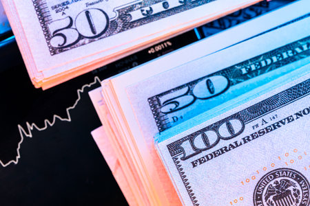 Dollars in front of a monitor with a price chart. Forex and trading.の写真素材