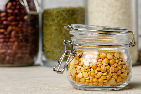 Raw cereals or beans in glass jars close up. Vegan and vegetarian food.の写真素材
