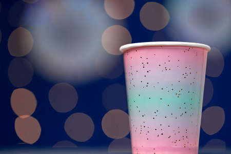 Pink disposable cup on blue bokeh backgroundの写真素材