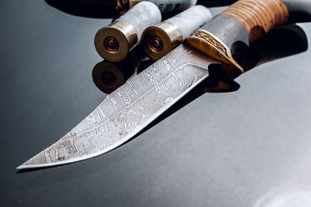 Hunting knife on black background with reflection