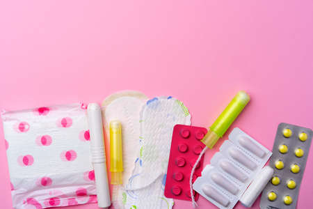 Ð¡ontraceptive pills, hygienic pads and tampons on pink backgroundの写真素材