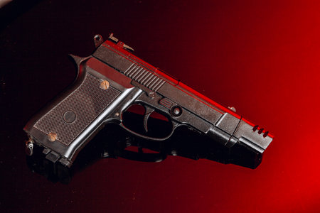 Black handgun on black background with reflection