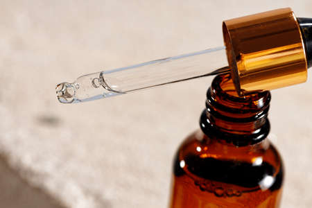 Glass bottle with cosmetic oil on cinder blockの写真素材