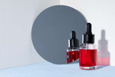 Creative photo with glass jar ofcosmetic oil and mirrorの写真素材