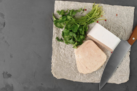Meat sausage on parchment on gray background