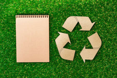 Craft paper on grass, recycling concept, top viewの写真素材