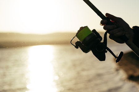 Fisherman hands holding fishing rod close upの写真素材