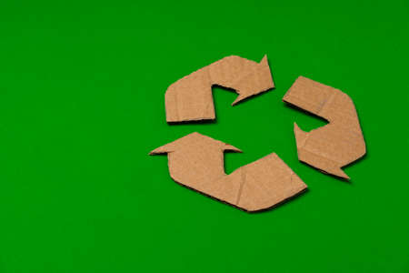 Paper recycling concept on green background top view