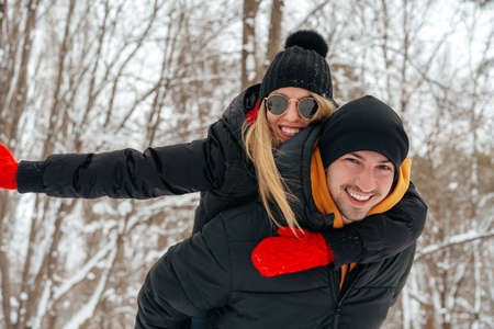 Happy couple hugging and smiling outdoors in snowy park
