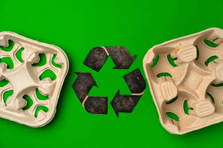Disposable eco-friendly cardboard package on green background