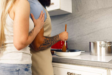 Young man and woman cooking food in kitchen together, happy couple preparing food
