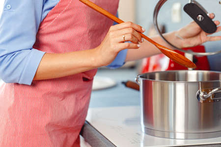 Unrecognizable woman standing in her kitchen close upの写真素材