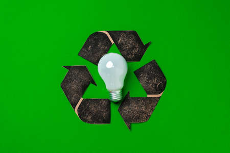Light bulb and recycling sign on green backgroundの写真素材