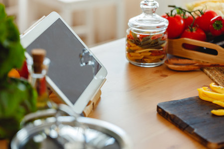 Kitchen table with food and digital tablet on it close upの写真素材
