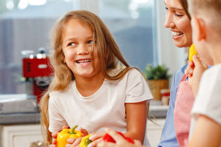 Woman and her kids cooking in kitchenの写真素材