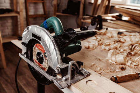 Electrical wheel saw on working table in carpentry workshop