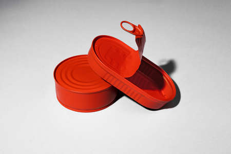 Red painted open tin can on gray background