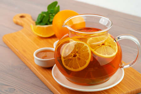 Glass teapot with black tea and pieces of citrusの写真素材