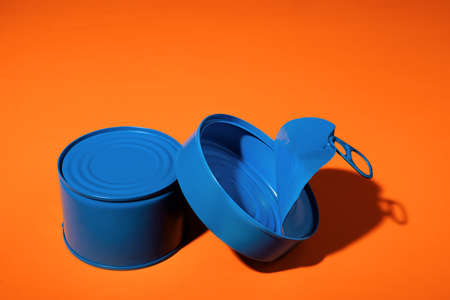 Aesthetic concept with blue painted tin can on orange backgroundの写真素材