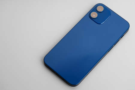 Blue modern smartphone with double-lens camera on gray backgroundの写真素材