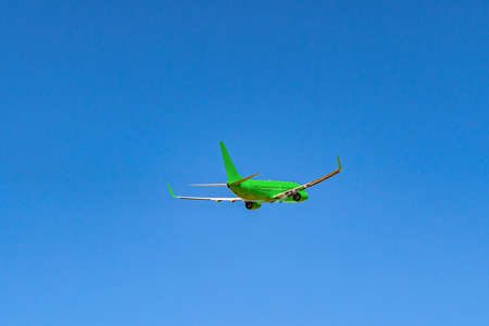 Passenger airplane flying against clear blue skyの写真素材
