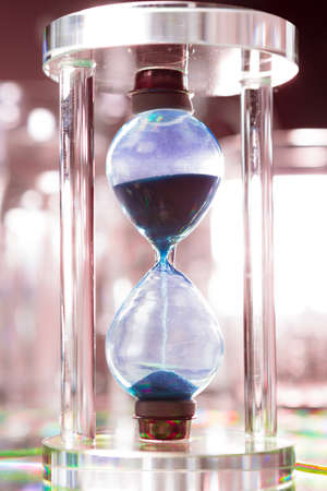 Blue hourglass on gray background close upの写真素材