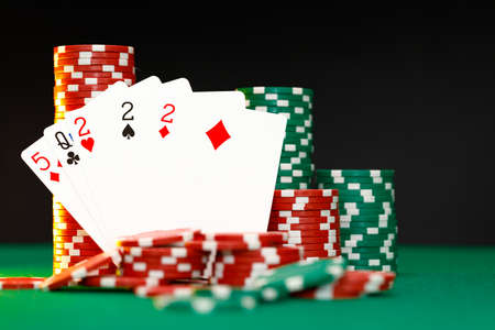 Poker chips and playing cards on black background