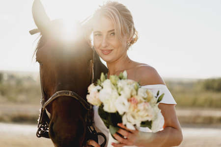 Portrait of a beautiful bride with horseの写真素材