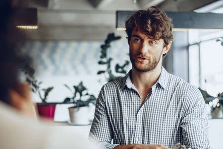 Close up photo of two male colleagues discussing project in office