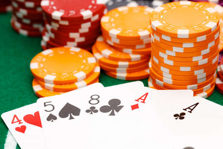 Playing cards and chips on green casino table background