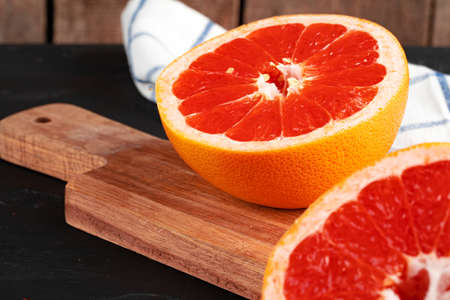 Cut oranges on wooden board on tableの写真素材