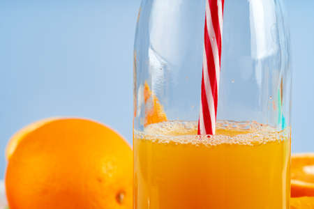 Bottle of orange juice and fresh oranges on tableの写真素材
