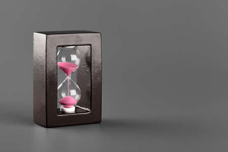 Hourglass with sand on gray background close upの写真素材