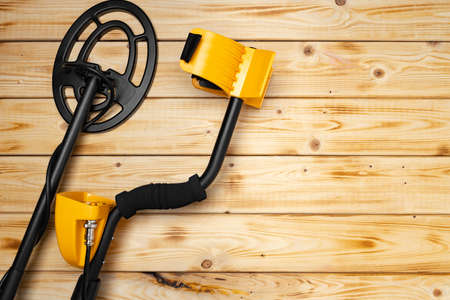 Metal detector on wooden background top viewの写真素材