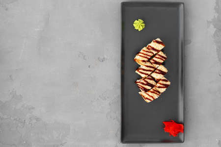 Sushi roll with sesame served on gray table