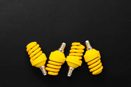 Yellow light bulbs on black background top viewの写真素材