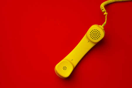 Yellow landline phone on red background top viewの写真素材