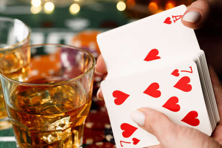 Female hand holding playing cards in casinoの写真素材