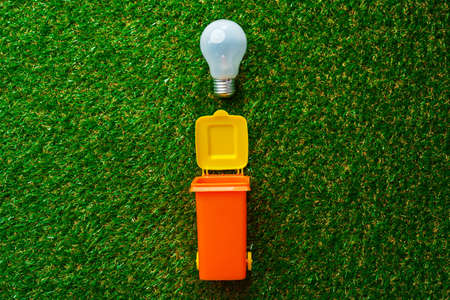 Garbage sorting concept with toy waste bin on paper background