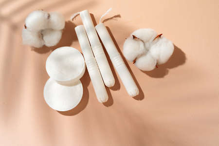 Hygienic tampons and cotton flower on paper background