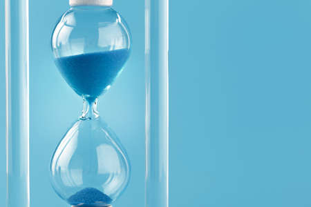 Close up of sandglass on paper backgroundの写真素材