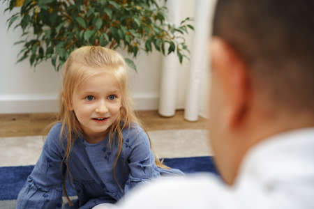 Grandfather and granddaughter playing together at homeの写真素材