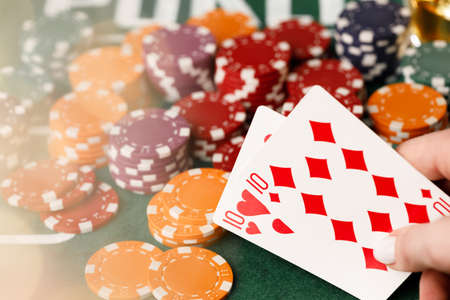 Female hand holding playing cards in casino