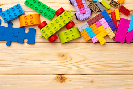 Toy constructor details on wooden background close up