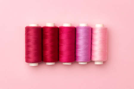 Set of threads spools on pink background