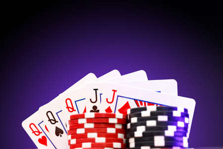 Poker chips and playing cards on black background