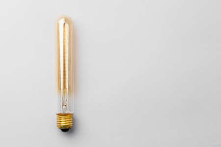 Light bulb on light grey paper background